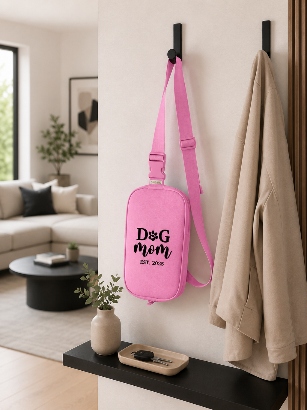 Pink bag with 'Dog Mom' text hanging on a wall hook in a living room.