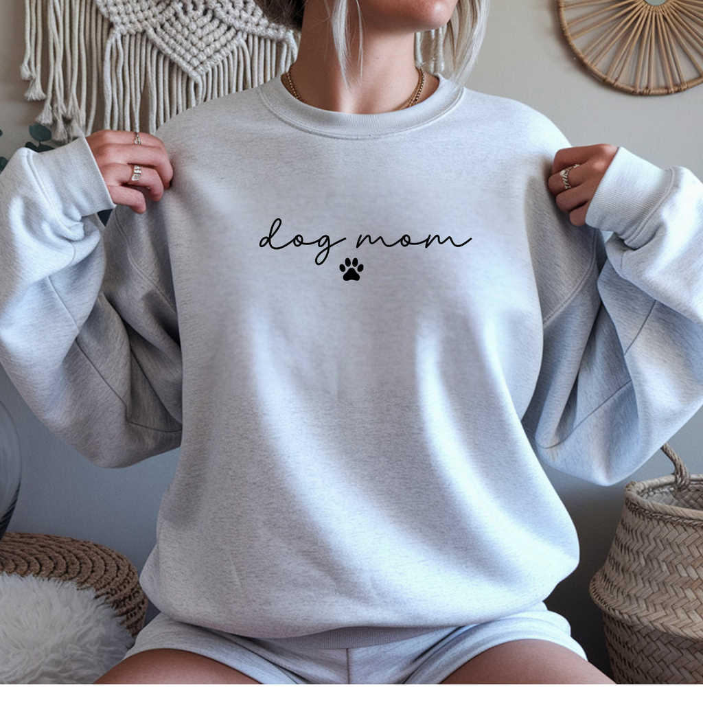 Person wearing a light gray sweatshirt with 'dog mom' text and paw print design.