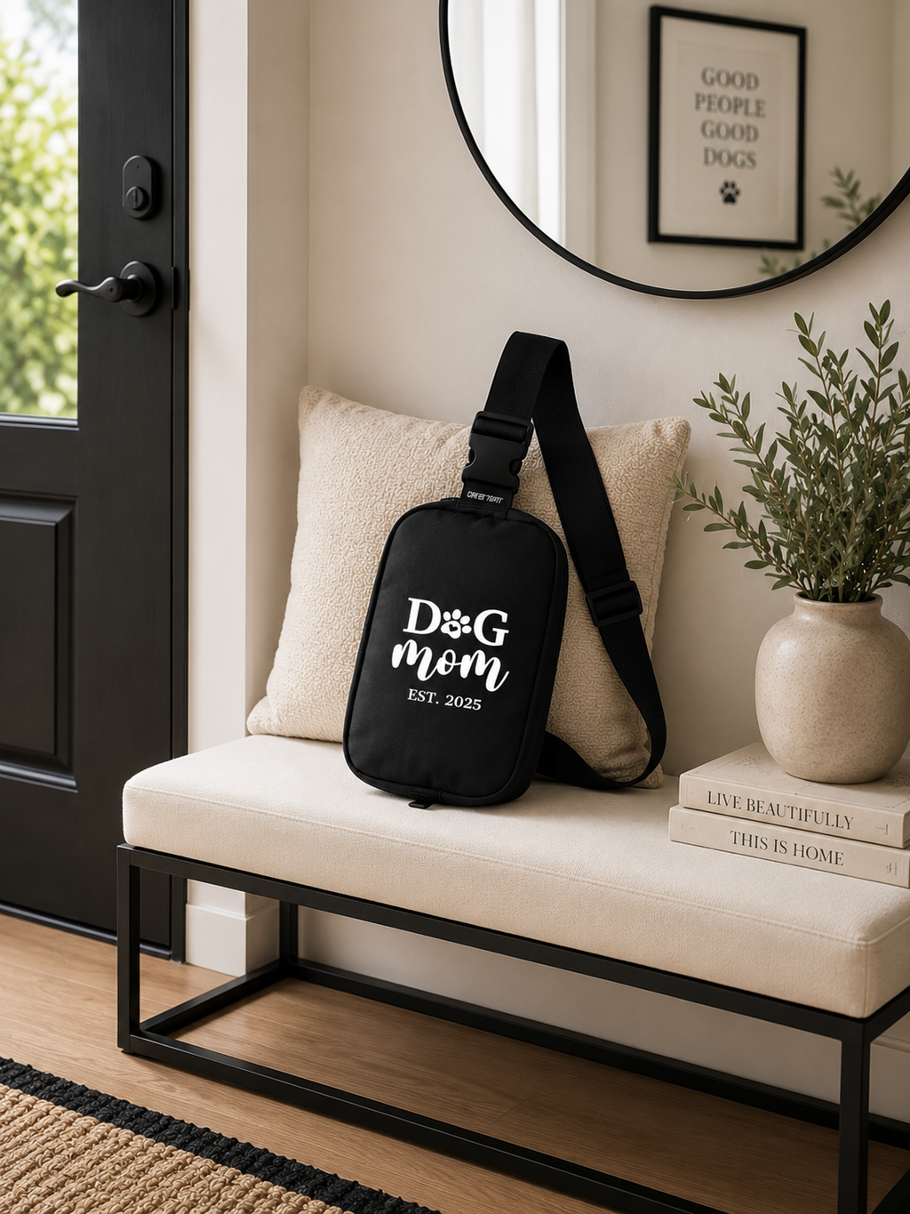 Black crossbody bag with 'Dog mom' Est. 2025 text on a bench in a home setting.